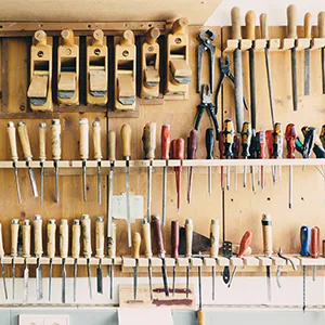 verschiedene Werkzeuge hängen an einer Wand